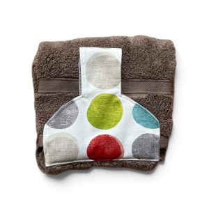 Hand towel to hang on an oven/kitchen or AGA rail. Fastened with a magnetic popper. Towel is mushroom coloured. Pattern placing on top varies.